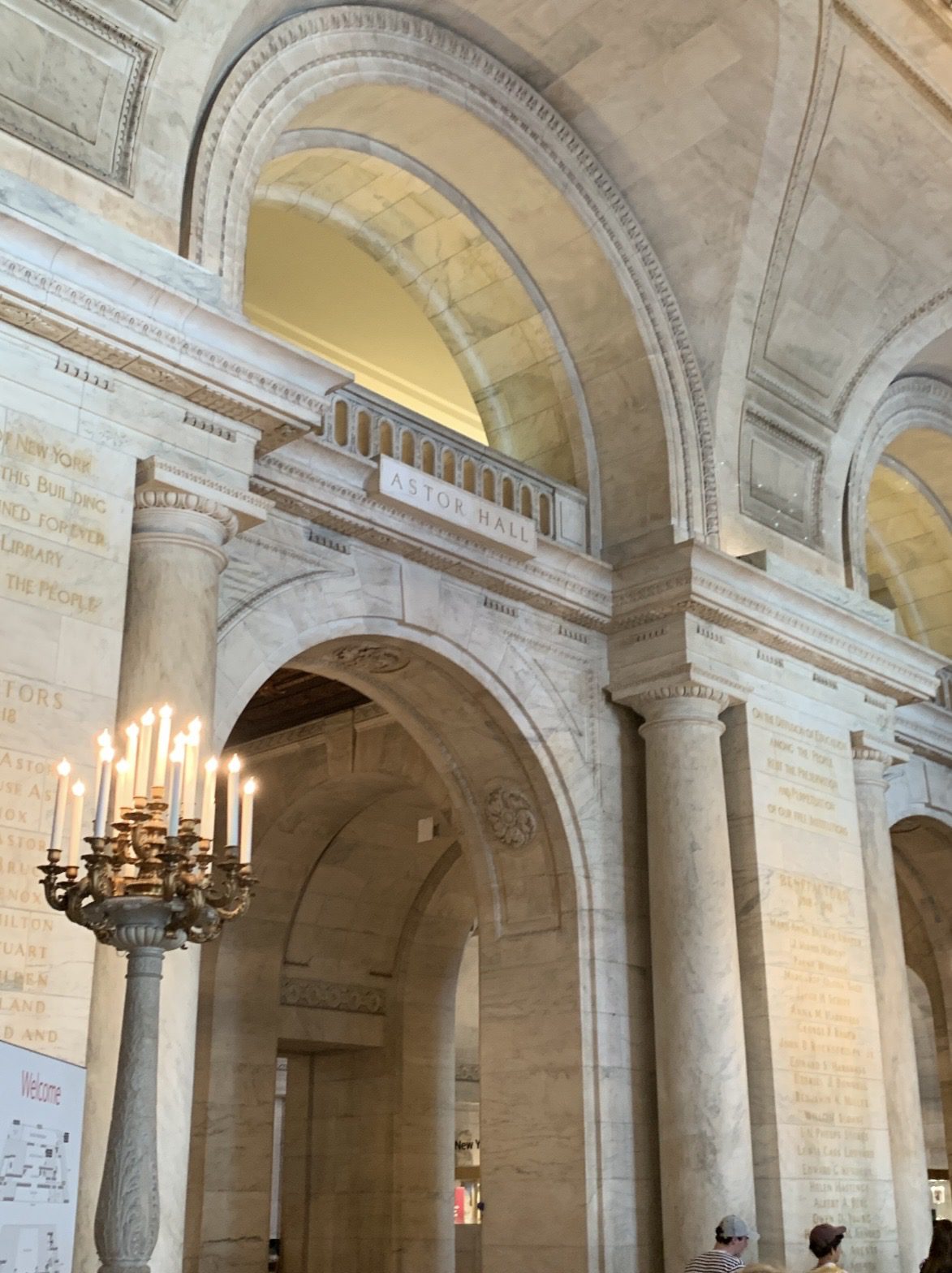 Astor Hall interior — New York Public Library, vaulted arches, stone columns, chandeliers
